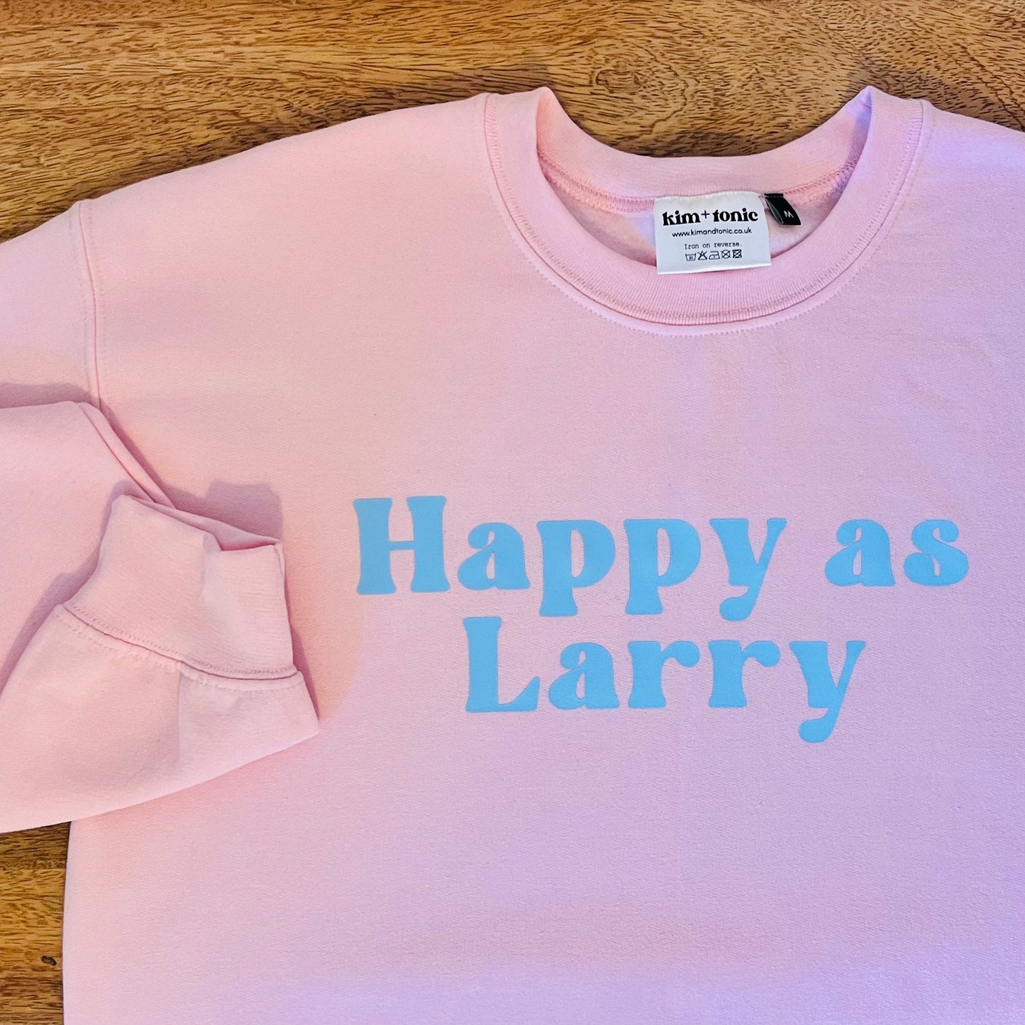 HAPPY AS LARRY SWEATSHIRT. Pink with blue print.