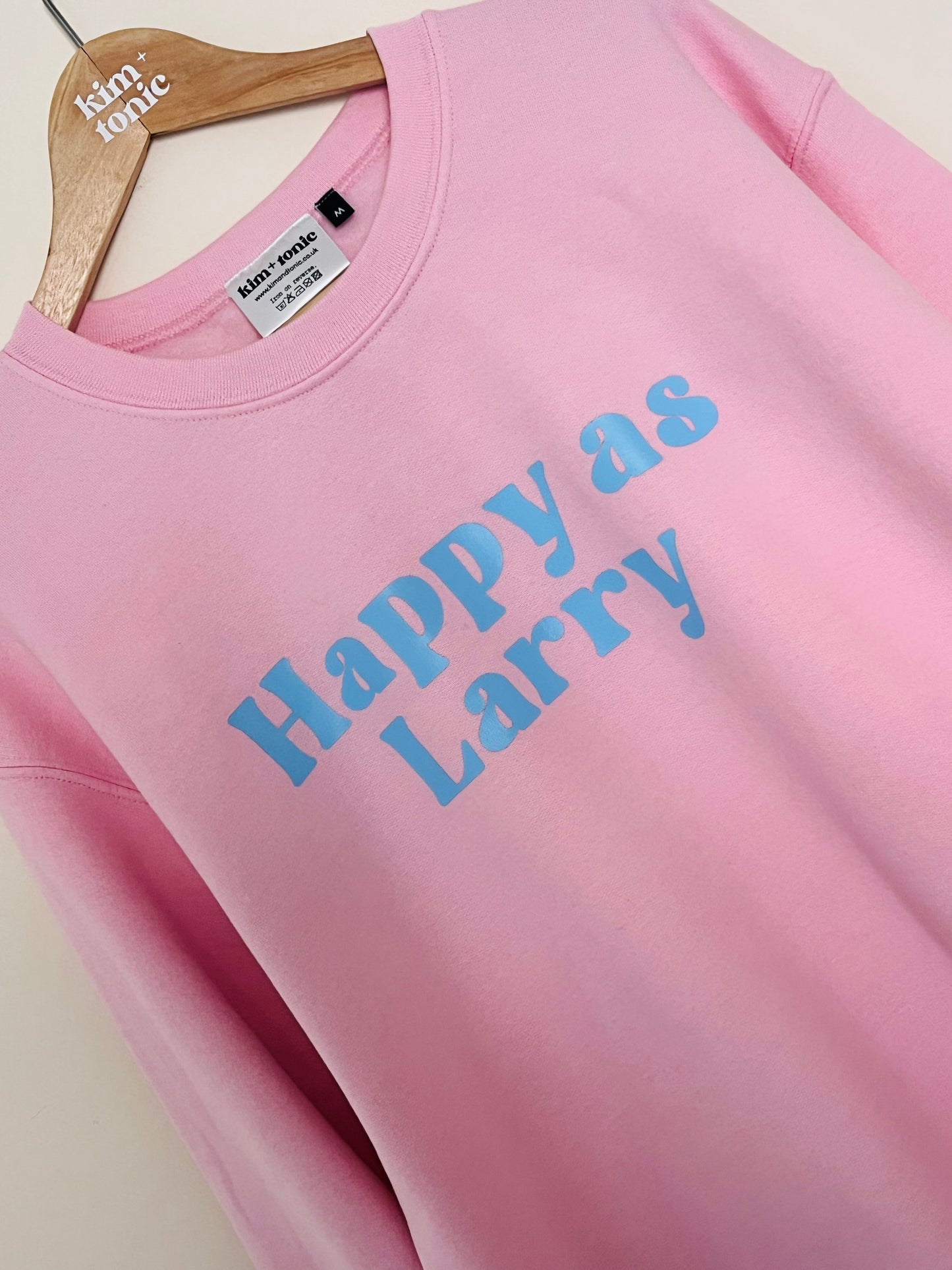 HAPPY AS LARRY SWEATSHIRT. Pink with blue print.