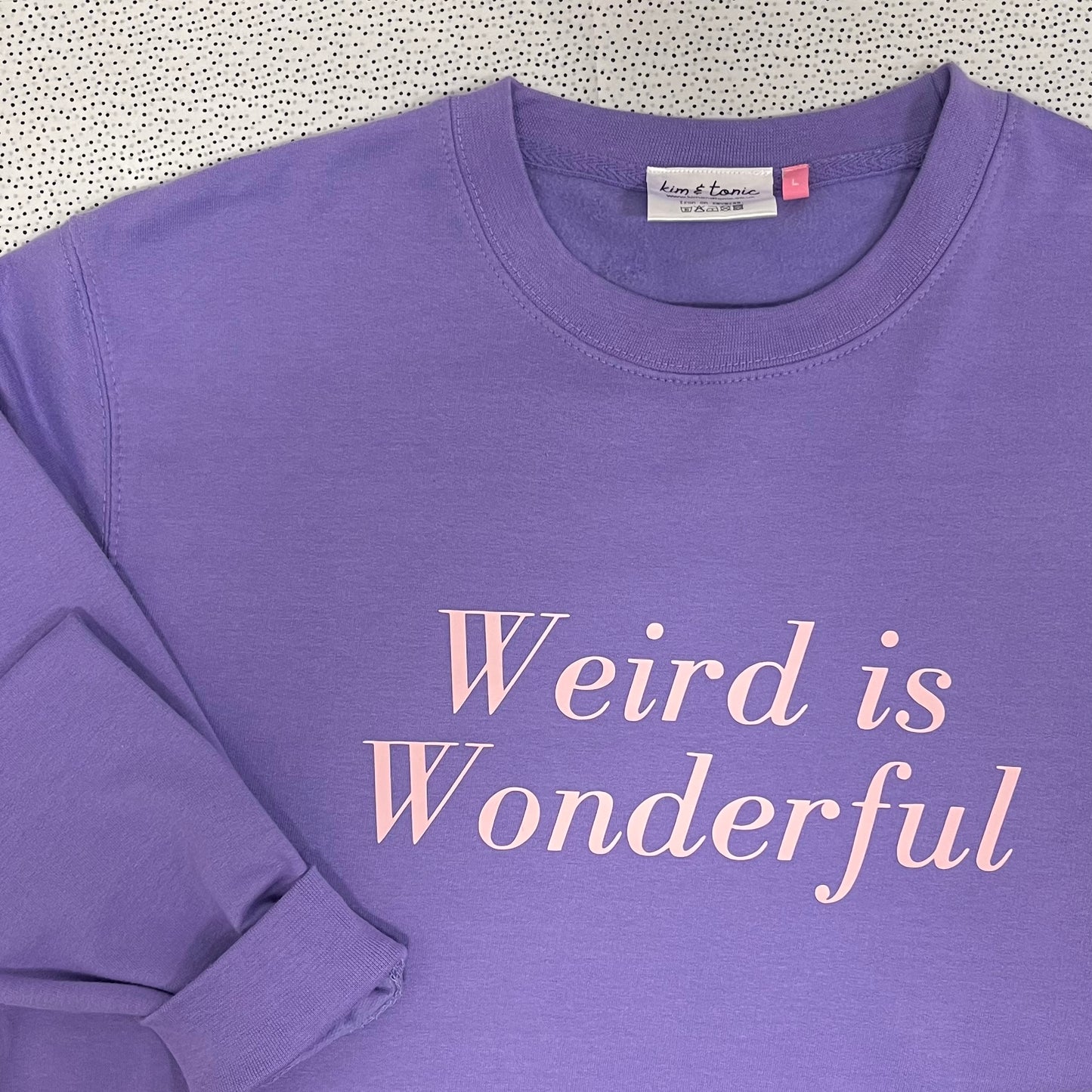 WEIRD IS WONDERFUL SWEATSHIRT. Purple with pink print.
