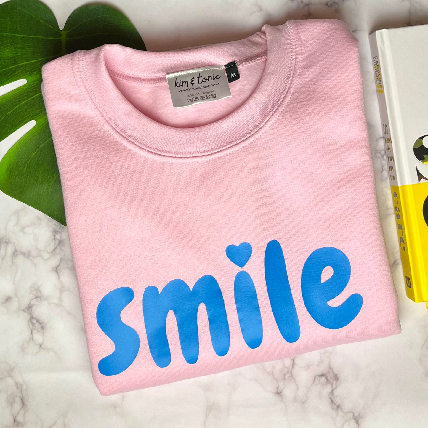 SMILE SWEATSHIRT. Light pink with blue print.