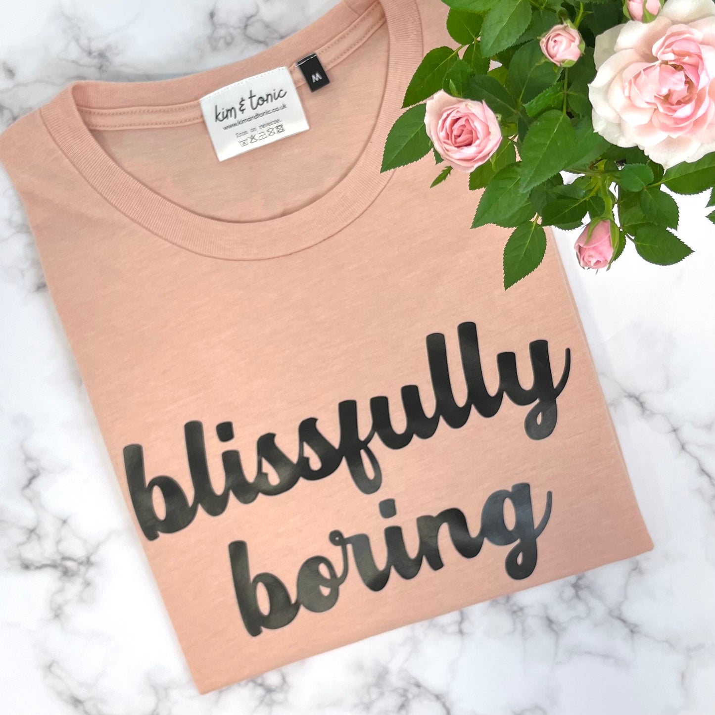 BLISSFULLY BORING T-SHIRT. Peach with black print.
