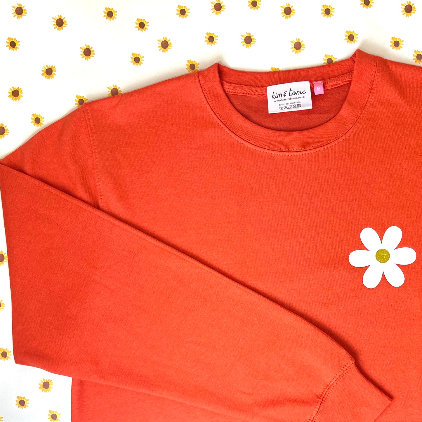 ORANGE DAISY SWEATSHIRT. With white and sparkly gold print.