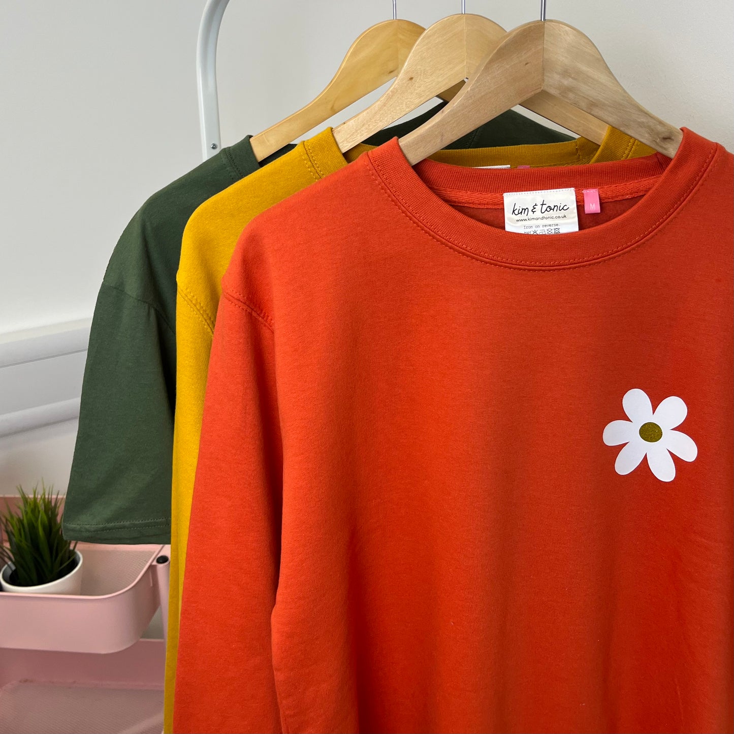 ORANGE DAISY SWEATSHIRT. With white and sparkly gold print.