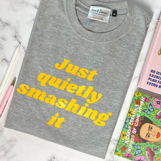 JUST QUIETLY SMASHING IT T-shirt. Grey with mustard print.