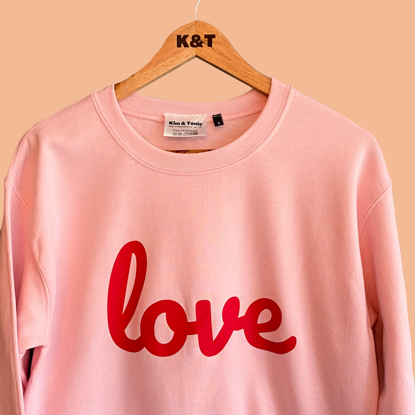 LOVE SWEATSHIRT. Pink with bright red print.